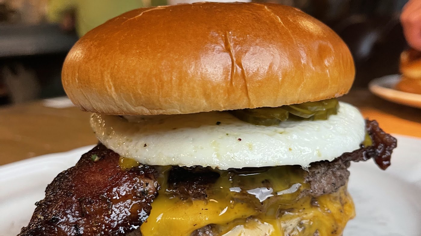 Au Cheval's bacon, egg, and cheese burger, dripping with melted cheddar